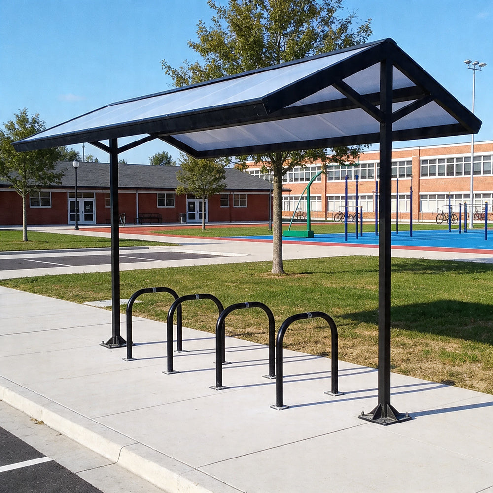 Bicycle shelter with bike racks on a sidewalk near a school building