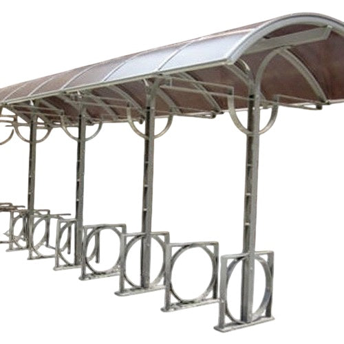 An arch-shaped bike shelter with multiple bike racks under a translucent polycarbonate roof, made of steel or aluminum frame.
