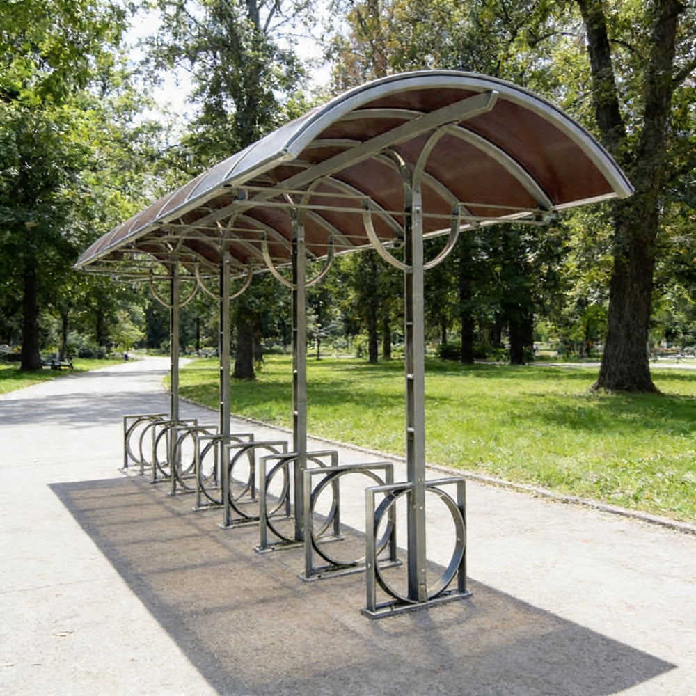 Interior of TAIMCO bike parking shelter with steel bike racks arranged under a curved canopy.