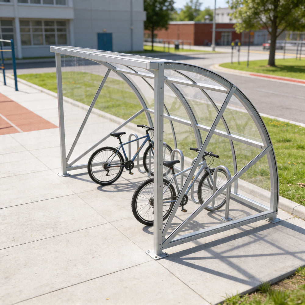 Bicycle shelter with two bicycles parked inside on a sidewalk.