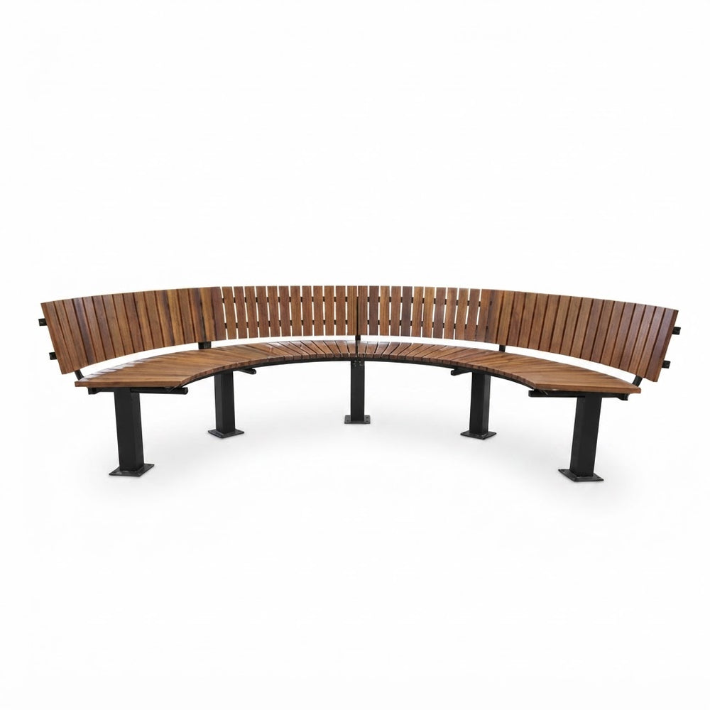 A curved outdoor bench with medium brown wooden slatted backrests and seat, supported by black metal posts, shown on a plain white background.