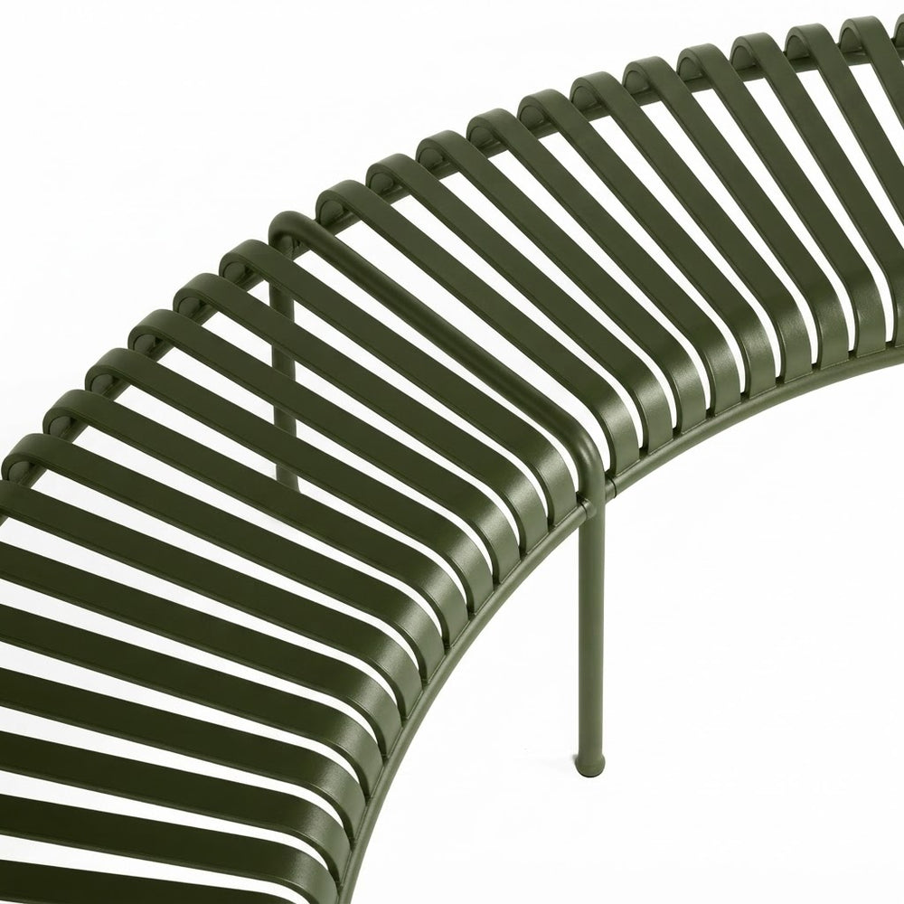 Close-up of a curved metal slat bench in an olive green finish, showing the parallel horizontal bars and support legs against a plain white background.