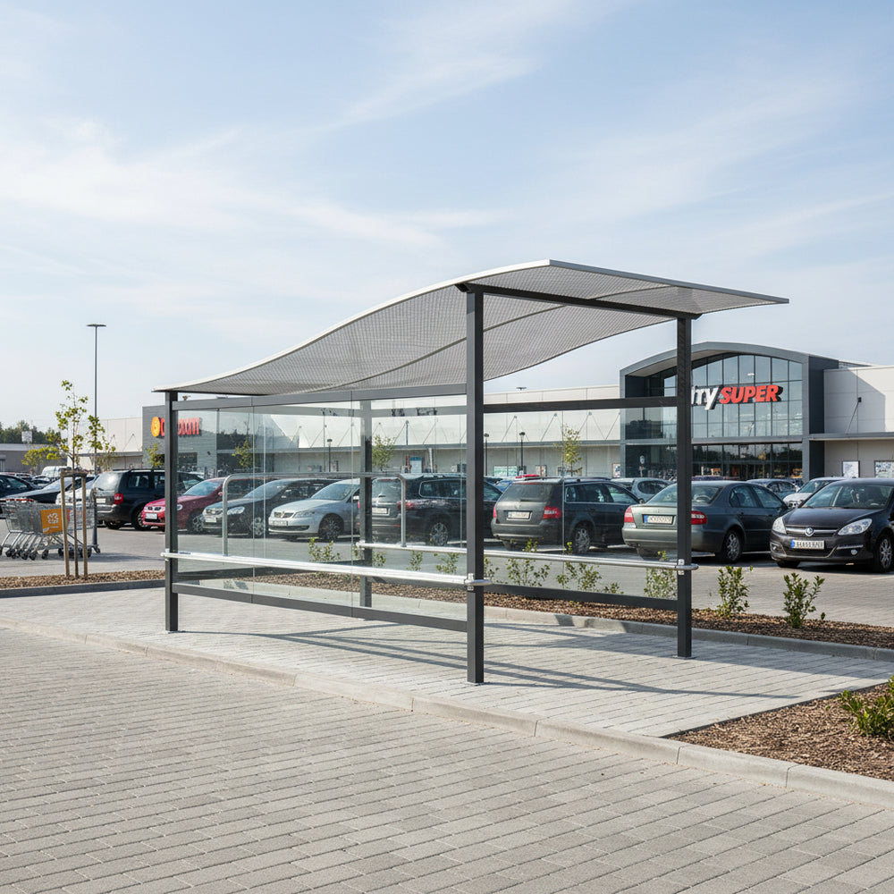 Rear angle of shopping cart shelter with curved roof and full glass back panel.
