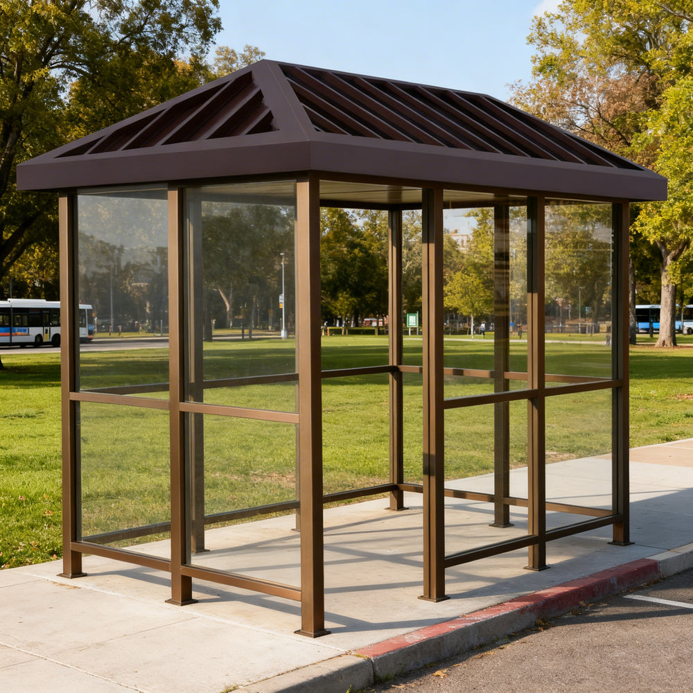 Rear angle of bus stop shelter with slanted roof and full glass back panel.
