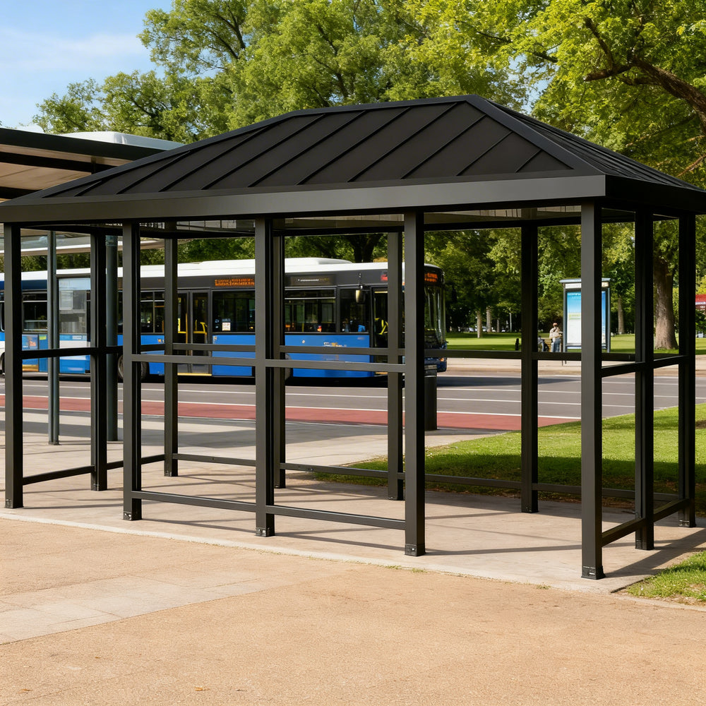 Rear angle of bus stop shelter with hip‑top roof and full glass back panel.