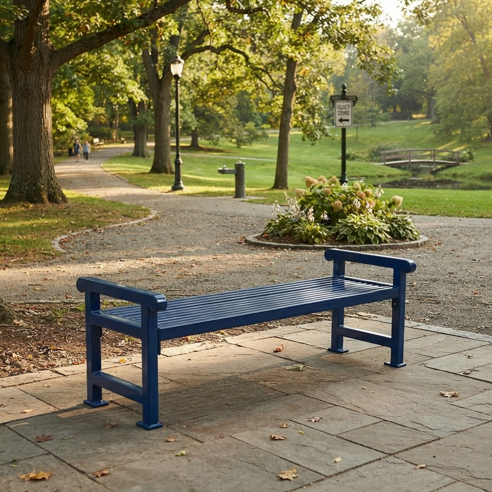 A dark blue outdoor park bench with a slatted seat and armrests, placed on a stone walkway in a sunny, tree-lined park.
