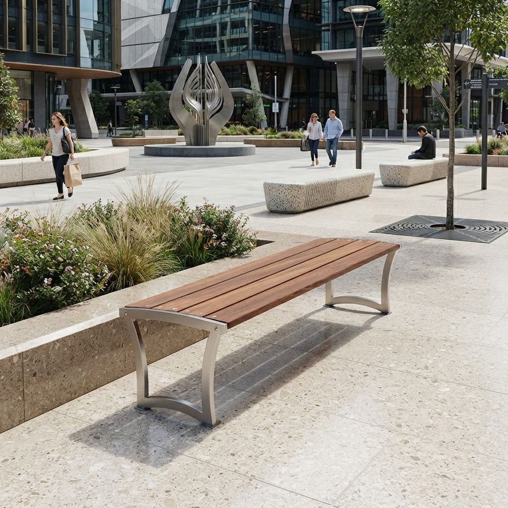 A modern outdoor bench with a brown wooden slat seat and curved silver metal legs, situated in a contemporary urban plaza with people walking in the background.