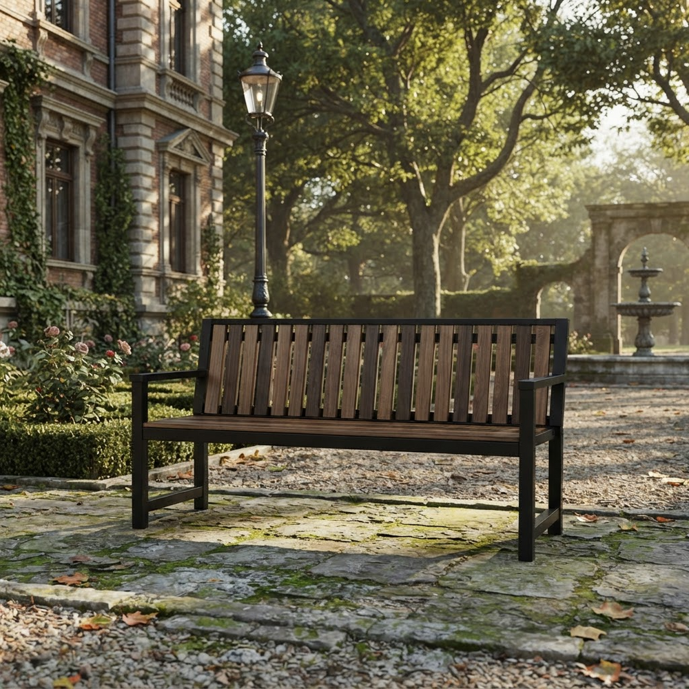 A dark brown outdoor wooden bench with a slatted back and seat, positioned on a stone path in a garden courtyard with a historic stone building, trees, and a lamp post in the background.