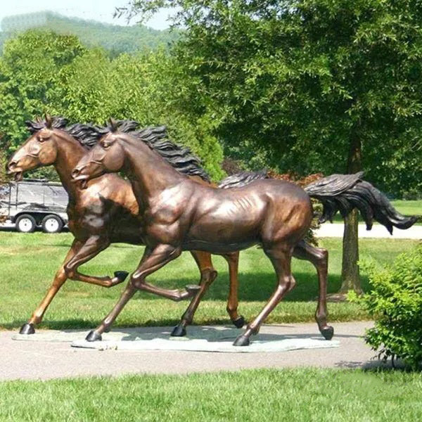 Pair of bronze running horse sculptures with raised front legs and realistic anatomical detail