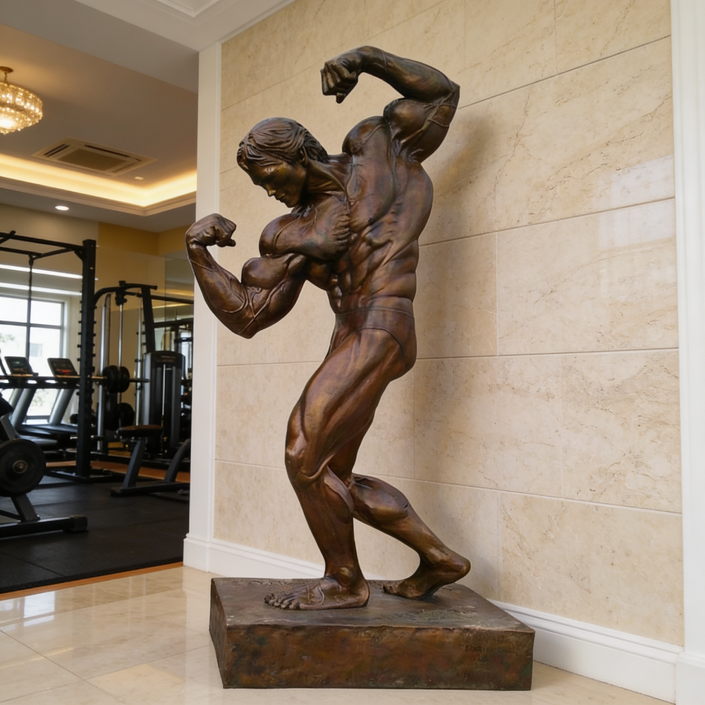 Bronze statue of a muscular figure in a gym setting
