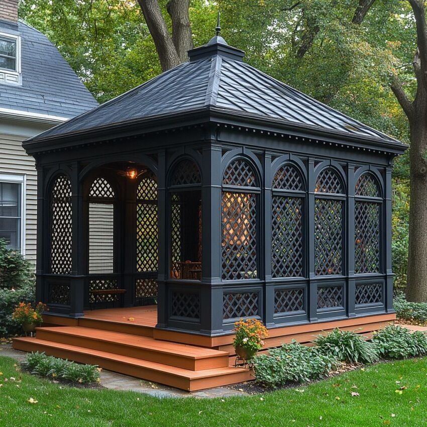 Black hexagonal gazebo with wooden steps in a garden setting