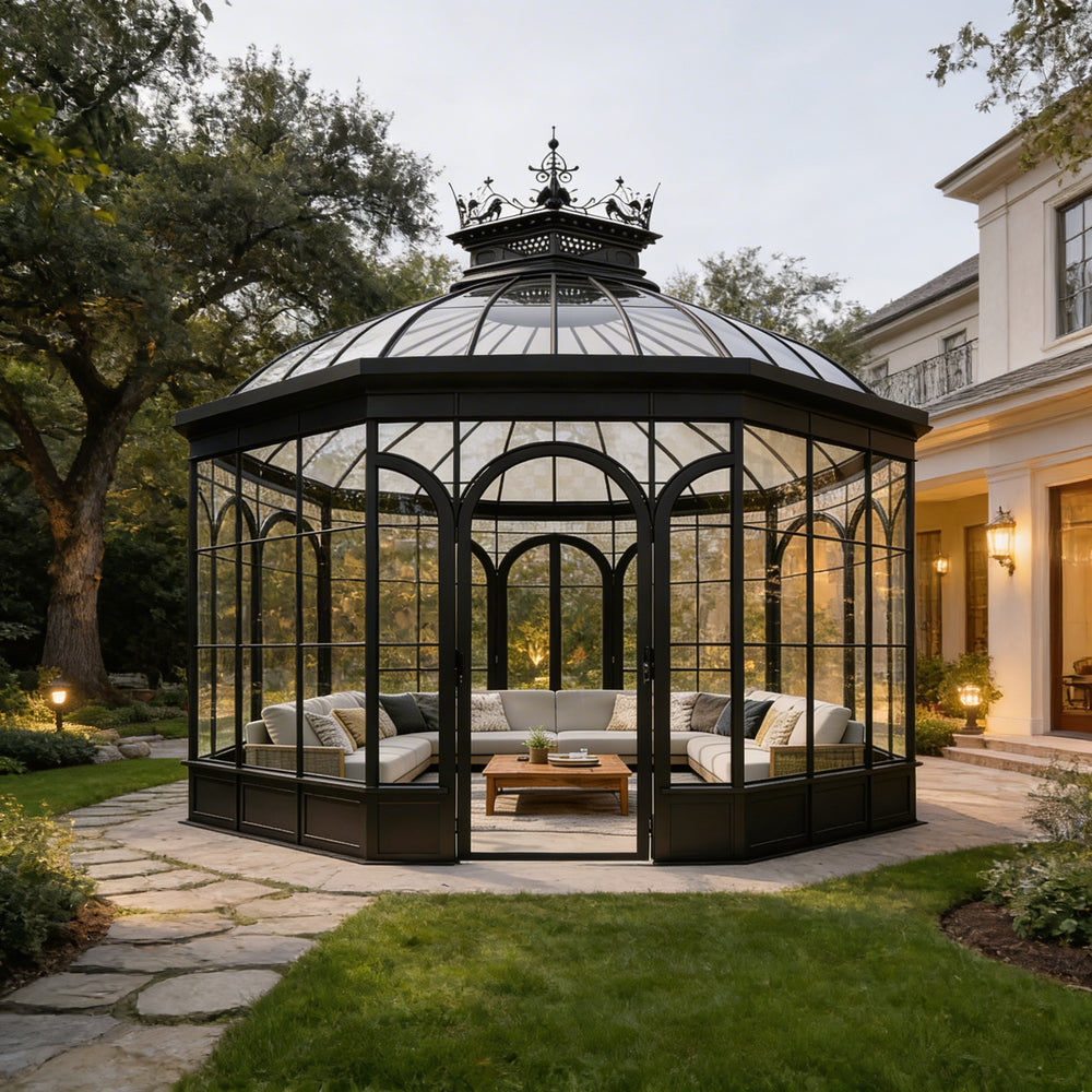 Octagonal glass gazebo with outdoor furniture in a garden setting.