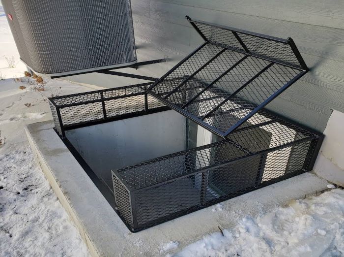 Powder‑coated steel window well grate with welded round‑bar grid and reinforced frame for basement safety and ventilation.