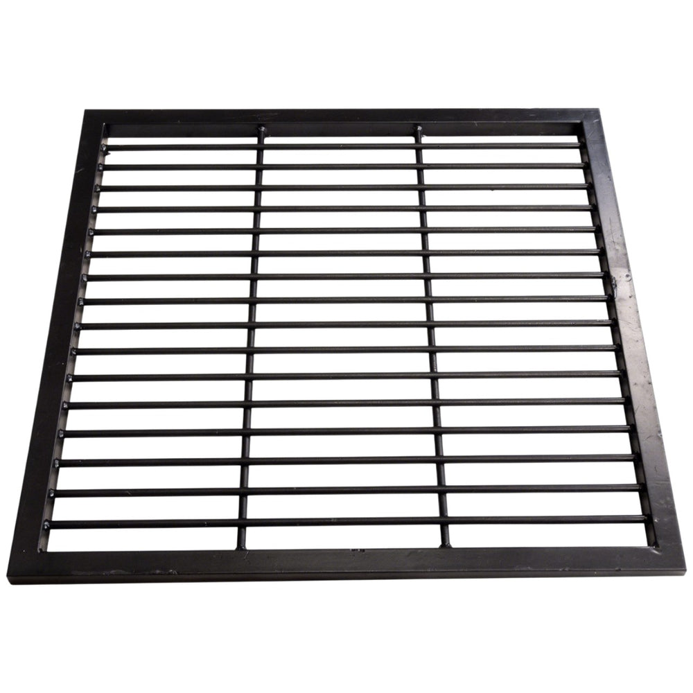 Black steel round‑bar window well grate installed beside a stone exterior wall with surrounding landscaping.