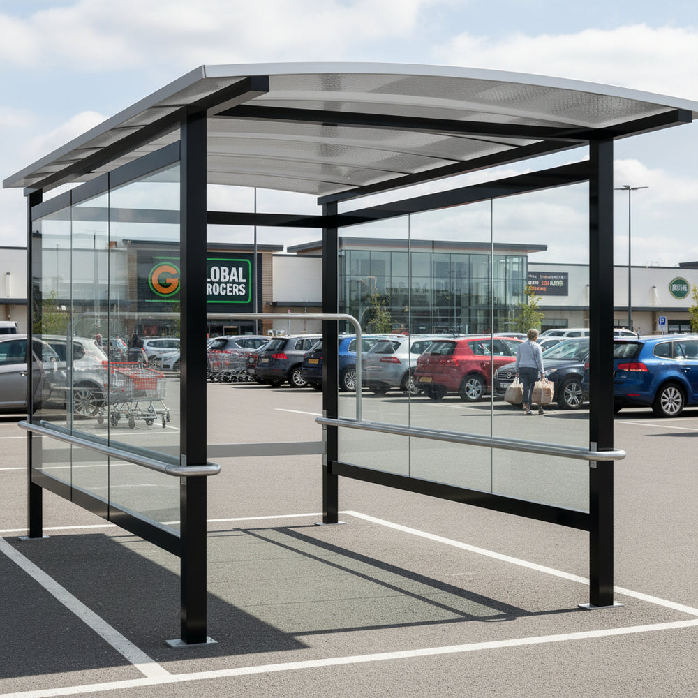 Side profile of modern shopping cart shelter featuring curved roof design and transparent glass enclosure.