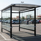 Rear angle of shopping cart shelter with curved roof and full glass back panel.