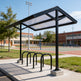 Bicycle shelter with bike racks in an outdoor setting, likely a school or community area.