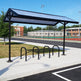 Bicycle rack with solar panel cover in an outdoor setting