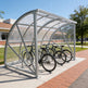 Bicycle shelter with bicycles underneath on a sunny day