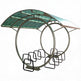 Circular outdoor shelter with green roof and metal chairs on a white background