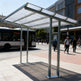 Bus stop with a shelter and people walking on a city street