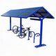 Blue bicycle parking shelter with three bicycles inside on a white background