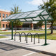 Bicycle shelter with bike racks on a sidewalk in front of a building