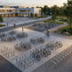 Bicycle parking area with people around a building in an urban setting