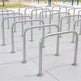 Row of metal bike racks on a tiled pavement