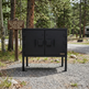 Black metal cabinet in a forested area with trees and a sign in the background.