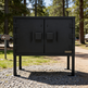 Black metal cabinet with 'Taimco' branding in a forested area