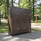 Brown metal locker with multiple doors in a park setting