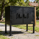 Black metal storage cabinet outdoors with 'Campground Storage' sign in the background