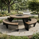 Outdoor round picnic-style table set with a circular top, curved wooden benches on both sides, and a black metal frame, shown in a landscaped park with trees and a paved walkway.