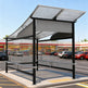 TAIMCO shopping cart shelter with wavy perforated roof and full glass side panels.