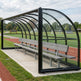 Empty sports referee shelter with curved roof and aluminum bench for sideline use.
