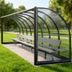 Rear angle of sports field shelter with curved roof and clear back panel.