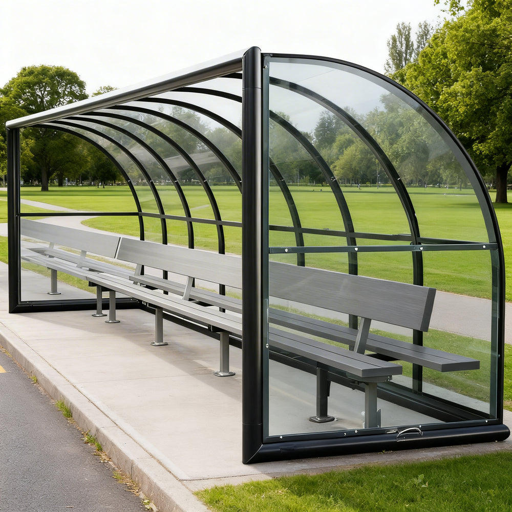Side profile of sports field referee shelter featuring curved roof and transparent side panels.