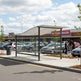 Interior of TAIMCO shopping cart shelter with stainless steel railings for organized cart storage.