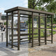 Rear angle of bus stop shelter with flat roof and full glass back panel.