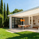 Louvered pergola casting patterned shadows on patio surface