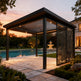 Modern pergola with decorative screen by a pool at sunset