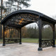 Decorative black metal gazebo with intricate designs in an outdoor setting.