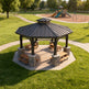 Front view of two‑tier hexagon gazebo with stone columns and integrated firepit.
