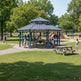 Side angle of octagon metal gazebo with raised roof cap and open‑air layout.