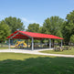 Front view of rectangular metal pavilion featuring pitched gabled roof.