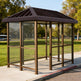 Rear angle of bus stop shelter with slanted roof and full glass back panel.