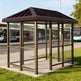 TAIMCO bus stop shelter installed outdoors with bronze frame and glass side panels for public transit use.