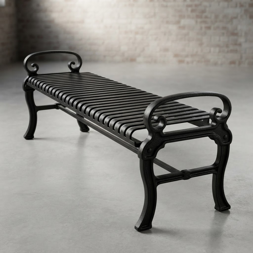 A black wrought-iron outdoor bench with curved scrollwork ends and a slatted seat, photographed on a concrete floor against a softly blurred brick wall.
