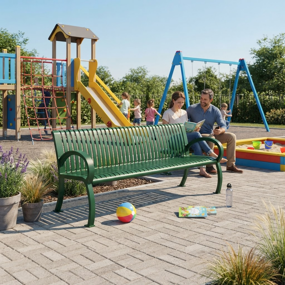 A green slatted outdoor bench in a playground setting, with a man and woman sitting on it and children playing in the background. The scene includes a blue swing set, wooden climbing structure, playground equipment, potted plants, and a colorful ball on the paved ground.